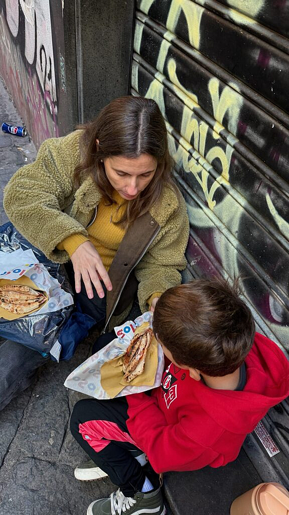 Comiendo pizza napolitana sentados en la calle en Nápoles