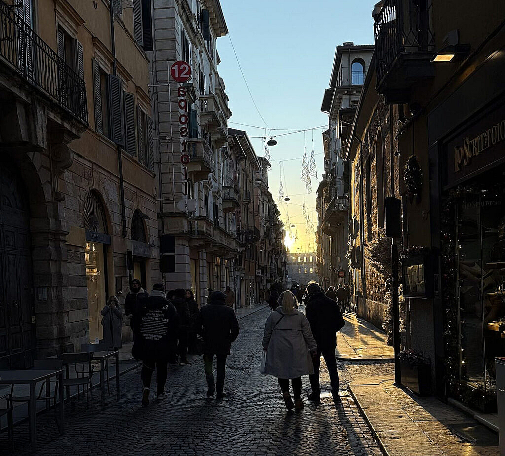 Via Mazzini peatonal de Verona con luces navideñas al atardecer