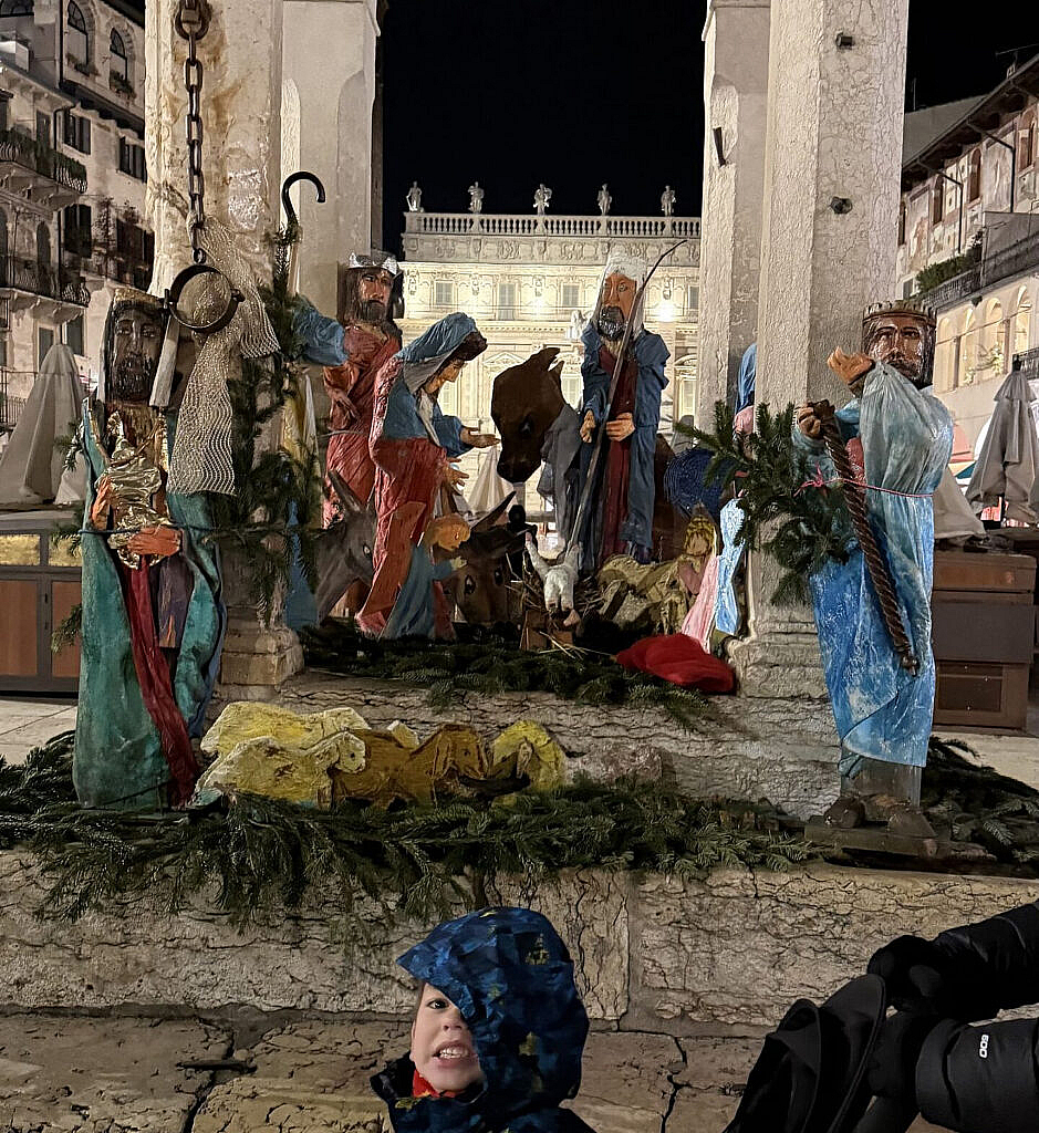Pesebre navideño bajo columnas en Piazza delle Erbe Verona