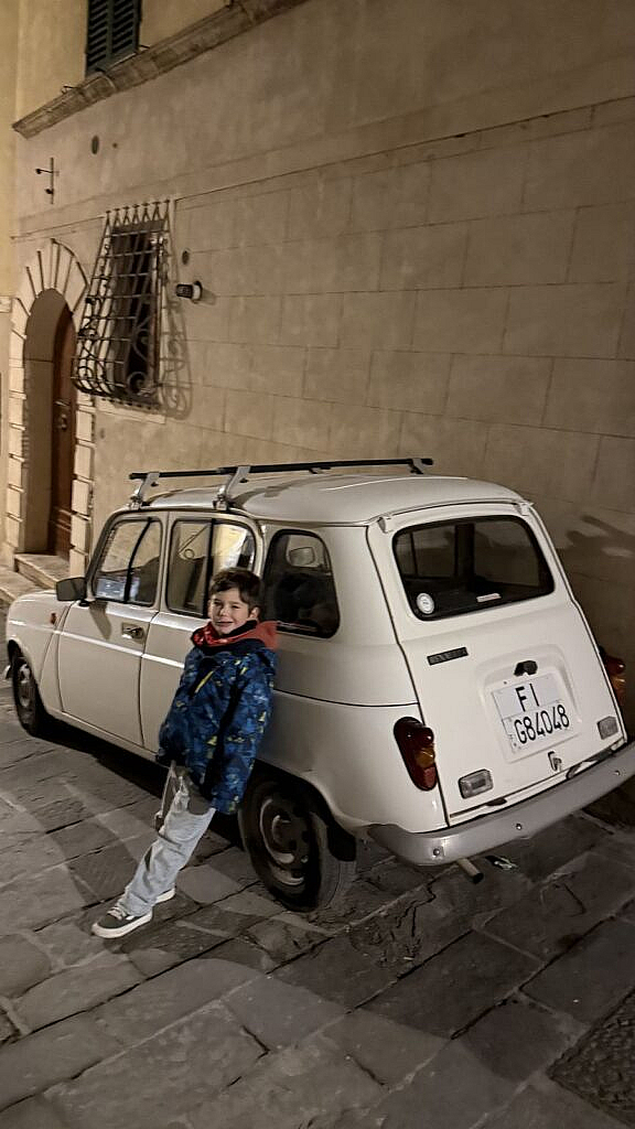 Vicente junto a un auto antiguo en una calle de Montepulciano