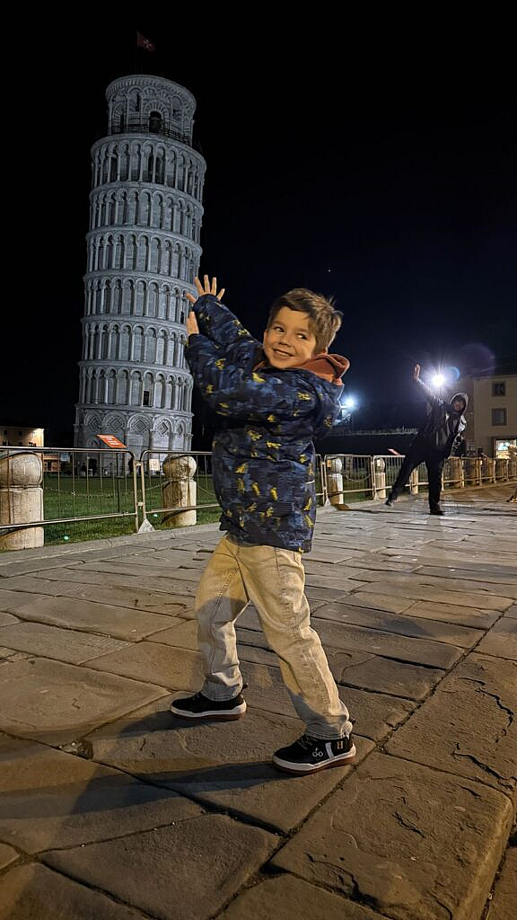 Vicente jugando frente a la Torre inclinada de Pisa de noche