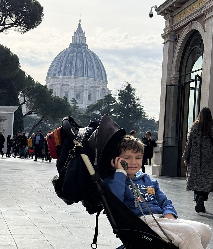 Vicente en el cochecito con la cúpula de San Pedro de fondo