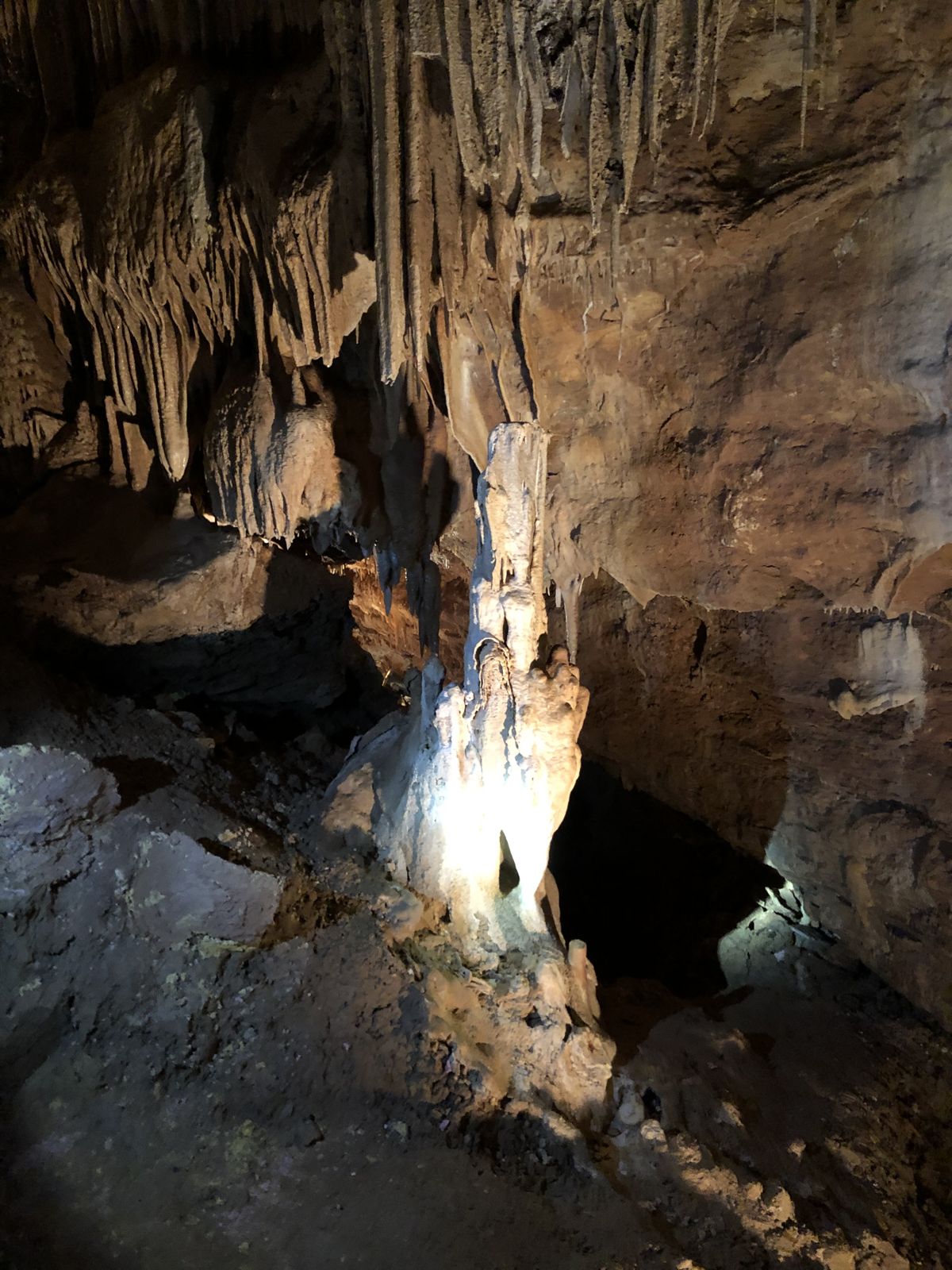 Una estalagmita iluminada desde abajo en las grutas de Lacave
