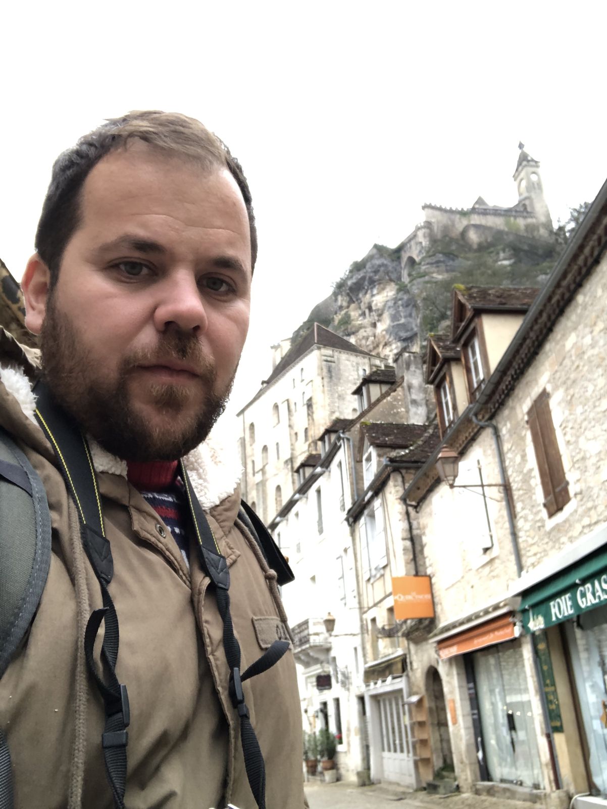 Agustín en la calle de Rocamadour, con el castillo arriba del acantilado