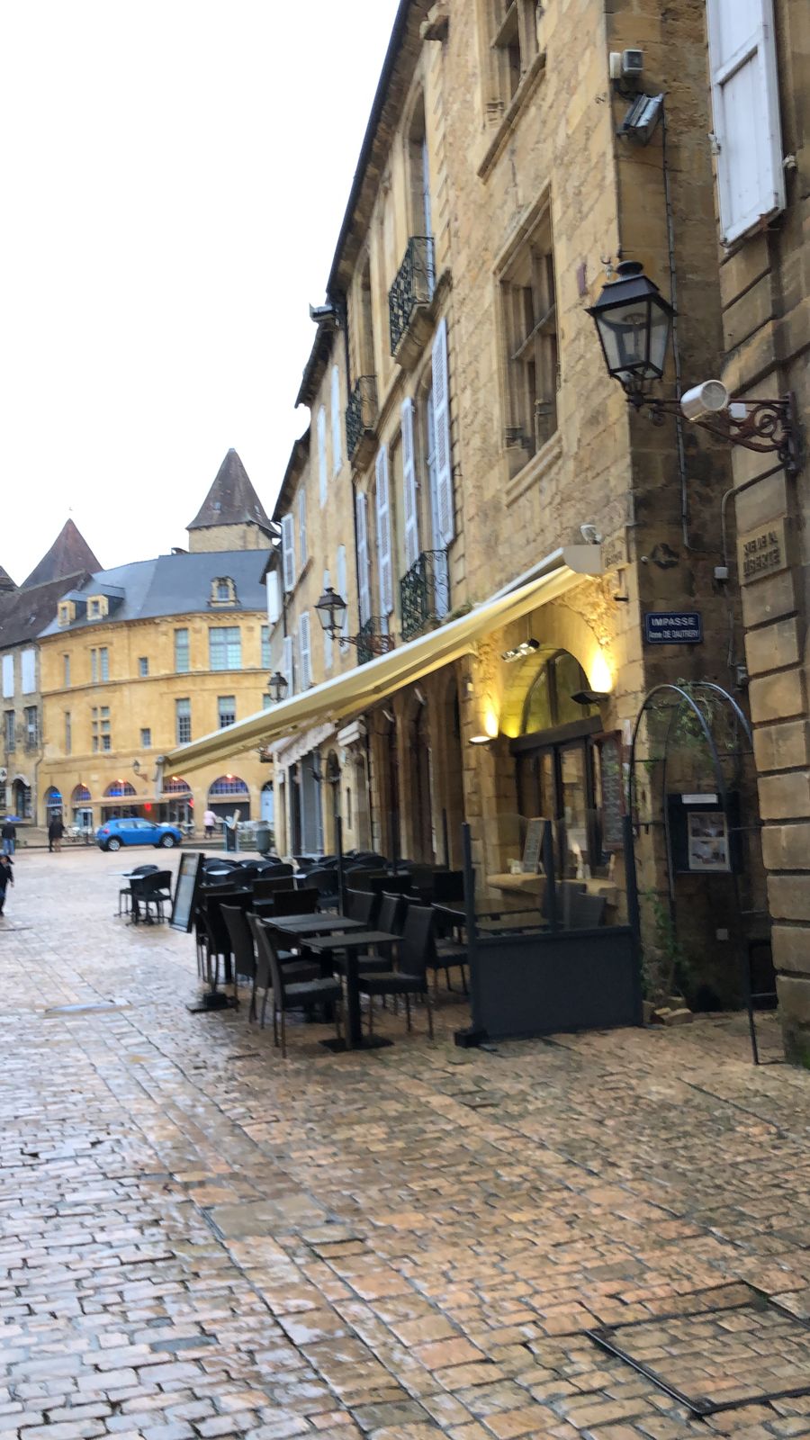 Calle de Sarlat con las terrazas de los bares mojadas