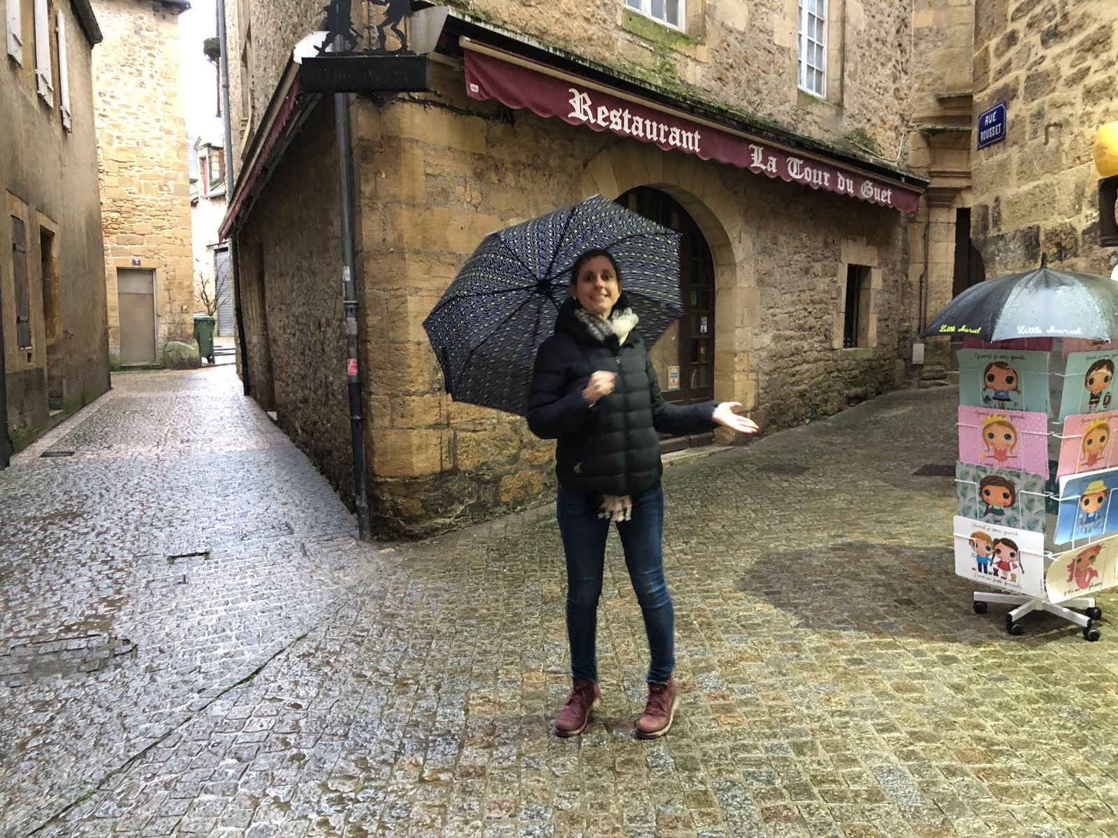 Florencia con paraguas en una plaza de Sarlat bajo la lluvia