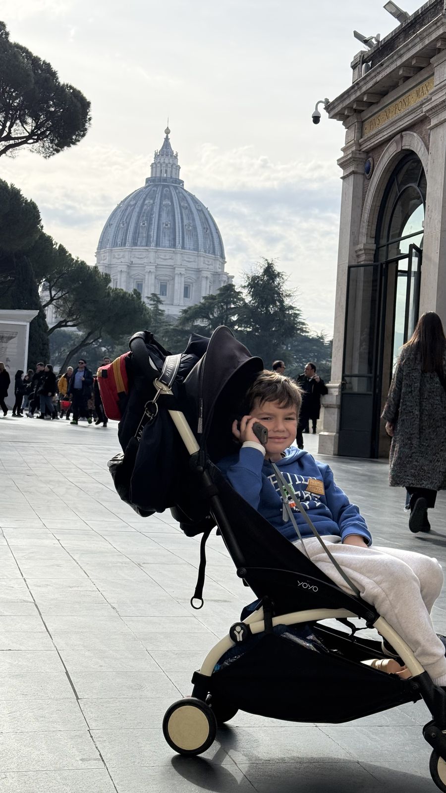 Vicente en el cochecito con la cúpula de San Pedro de fondo