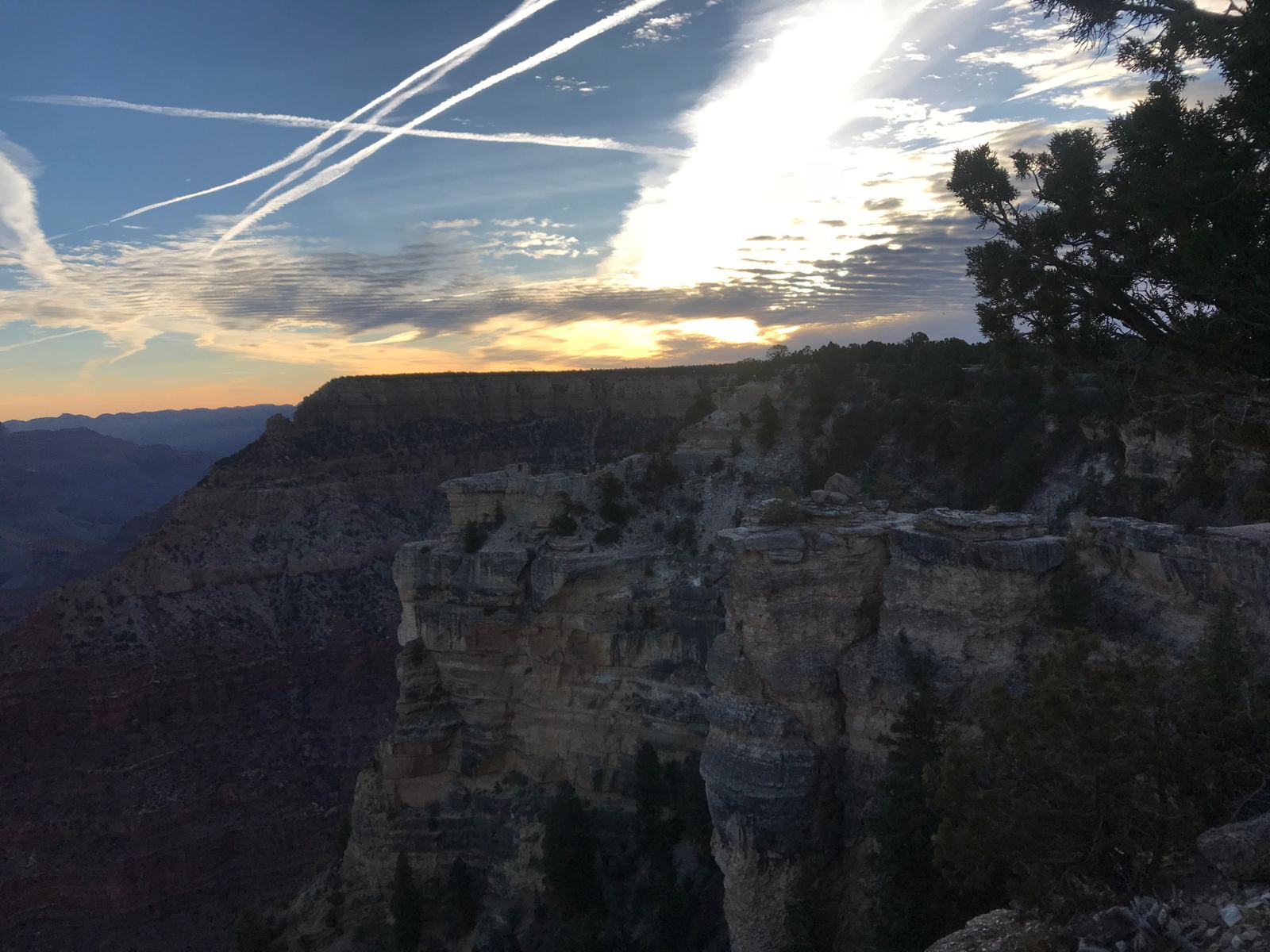 Atardecer en el Gran Cañón, con estelas de aviones cruzando el cielo