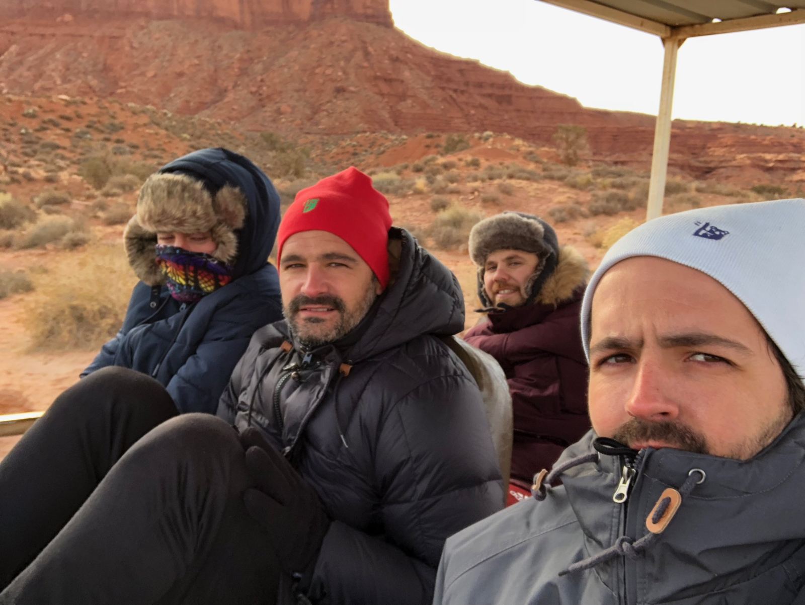 Los cuatro amigos abrigados en la camioneta abierta del tour por Monument Valley
