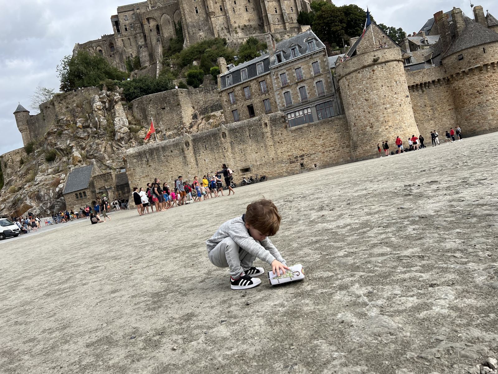 Vicente jugando en la arena al pie de las murallas del Mont Saint-Michel